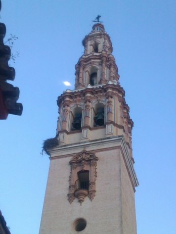The tower of Écija's St Gil church, with the moon above a stork's nest